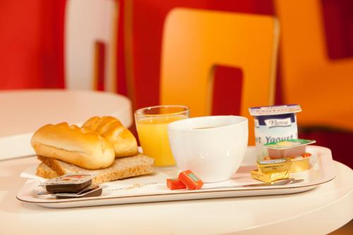 a plate of food with bread and a glass of orange juice at Premiere Classe Tours Sud - Chambray Lès Tours in Chambray-lès-Tours