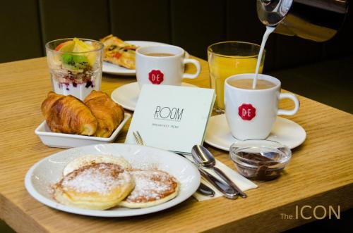 
a table topped with two plates of food and a cup of coffee at The ICON Hotel & Lounge in Prague
