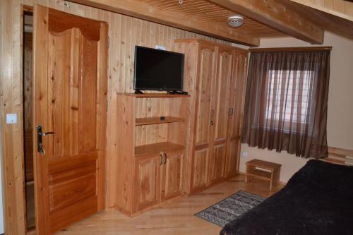 a room with a tv and a door with a television at У Гуцула in Mukacheve