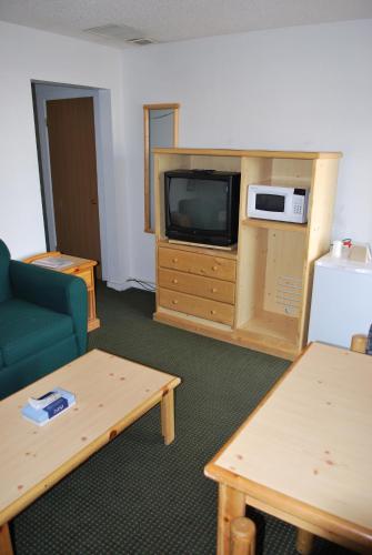 a living room with a tv and a couch and a table at Central Motel in Great Falls