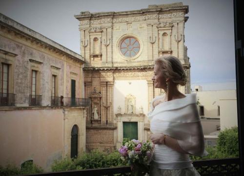 una mujer está parada frente a un edificio en Relais Monastero Santa Teresa - Albergo Diffuso, en Nardò