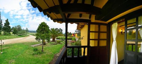 a door to a house with a view of a road at Hotel Hacienda El Salitre in Paipa