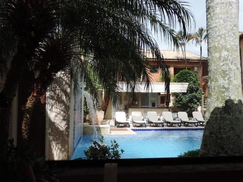 a swimming pool with chaise lounges and lounge chairs at Hotel Costa Balena-Piscina Aquecida Coberta in Guarujá