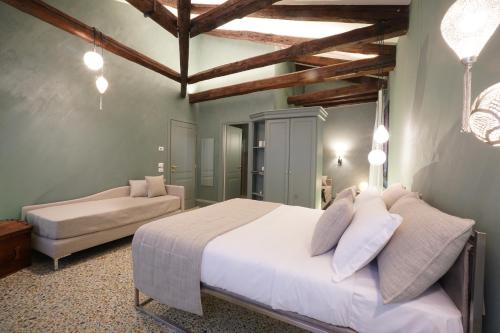 una camera con un grande letto bianco e un divano di P 1779 a Venezia