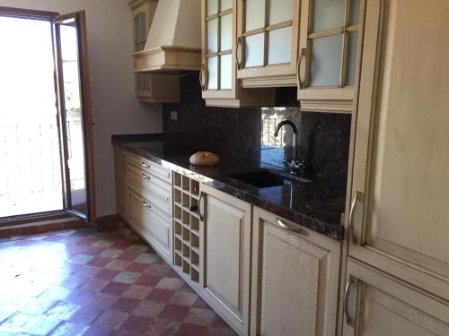 a kitchen with white cabinets and a black counter top at Casa Rural de Jaime in Medinaceli