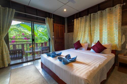 1 dormitorio con 1 cama grande con arcos azules en Kanya Cozy Bungalows Kata, en Kata Beach