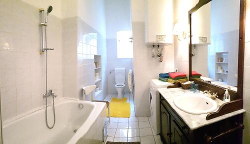 uma casa de banho com uma banheira, um lavatório e um WC. em Villa Eisenwerk em Wilhelmsburg