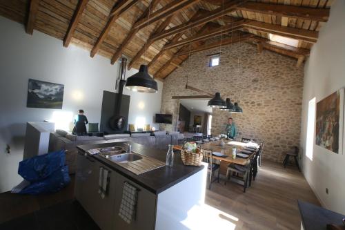 une cuisine et une salle à manger avec un mur en briques dans l'établissement La Maison des Champs, à Saint-Agrève