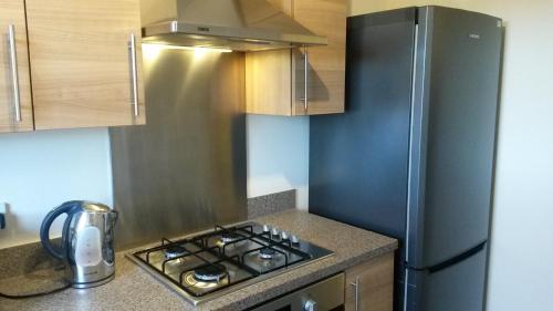 a kitchen with a stove and a refrigerator at Crystal Apartments in Airdrie