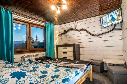 un dormitorio con una cama y una ventana en Apartamenty Góraleczka z widokiem- pokój zabaw, en Czarna Góra