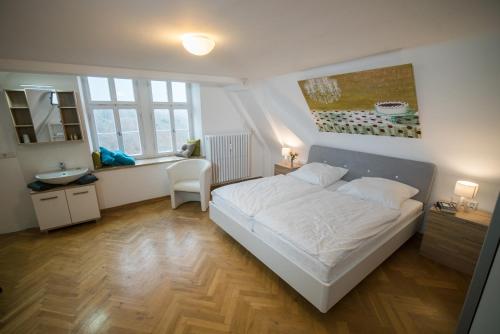 um quarto com uma grande cama branca e um lavatório em Schlosshotel Kirchberg em Kirchberg an der Jagst