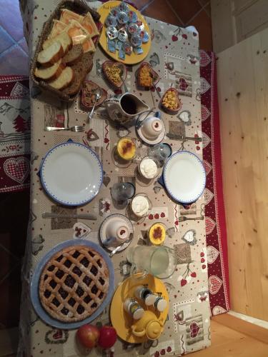 a table with plates of food on top of it at Maso Toneto in Castello di Fiemme