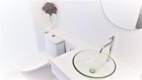 a white bathroom with a sink and a mirror at Trat 101 Hotel - SHA Certified in Trat