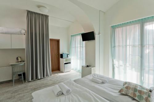 1 dormitorio con 1 cama blanca grande con almohadas blancas en Městský penzion Mikulov en Mikulov