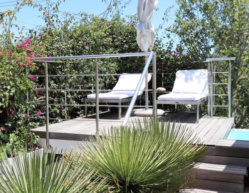 - deux chaises assises sur une terrasse à côté d'une piscine dans l'établissement DysArt Boutique Hotel - Solar Power, au Cap