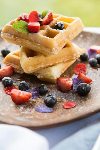 a plate of waffles with fruit on it at Cuesta Serena Boutique Hotel in Huaraz