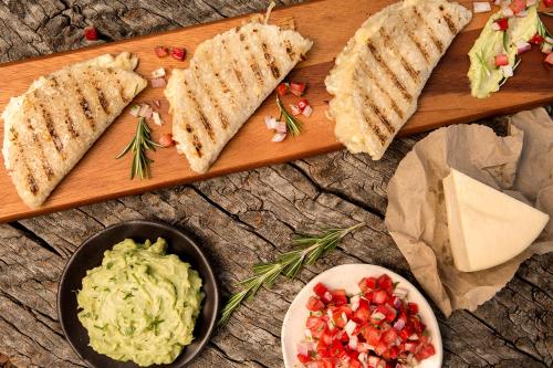 a wooden cutting board with sandwiches and a bowl of guacamole at Cuesta Serena Boutique Hotel in Huaraz