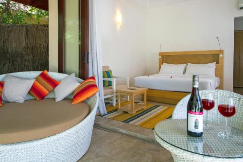 a room with a bed and a table with a bottle of wine at Summer Island Maldives in North Male Atoll