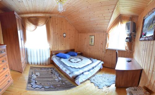 ボロフタにあるKarpatskyi Gominの木製の部屋にベッド1台が備わるベッドルーム1室があります。