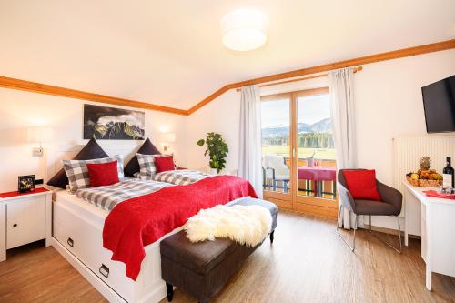 a bedroom with a large bed with a red blanket at "Haus Berktold" - Annehmlichkeiten von 4-Sterne Familien-und Wellnesshotel Viktoria können mitbenutzt werden in Oberstdorf