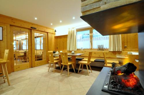 a kitchen and dining room with a table and chairs at Hotel Traube - Stelvio in Stelvio