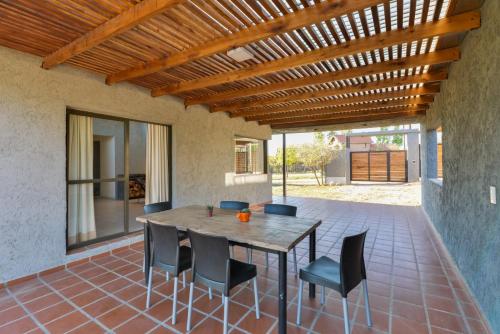a patio with a wooden table and chairs at Casas Acrux in Nono