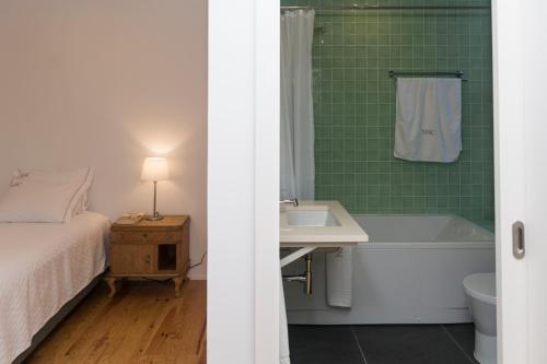 a bathroom with a bed and a tub and a sink at Quinta Nossa Senhora do Cabo in Lagoa