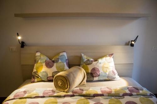a bedroom with a bed with pillows on it at Apartments Fewo in Bolzano