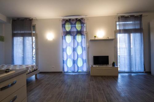 a bedroom with a bed and a tv and curtains at Apartments Fewo in Bolzano