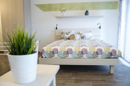 a bedroom with a bed and a plant on a table at Apartments Fewo in Bolzano