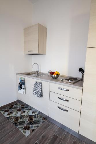 a kitchen with white cabinets and a bowl of fruit at Apartments Fewo in Bolzano