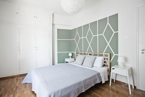 a bedroom with a large bed and a wall at Home Sweet Home in Athens