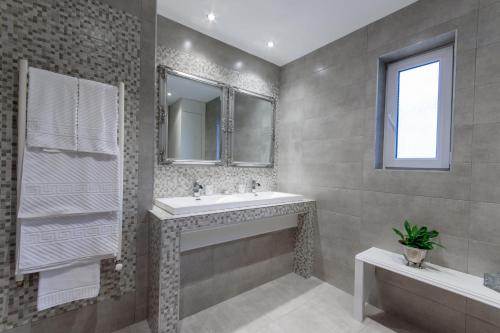 ein Badezimmer mit einem Waschbecken, einem Spiegel und einer Badewanne in der Unterkunft Williams House in Hunedoara