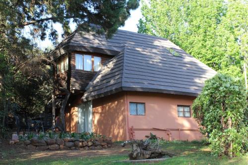 une petite maison rose avec un toit noir dans l'établissement Treks, Trips and Trails, à Champagne Valley