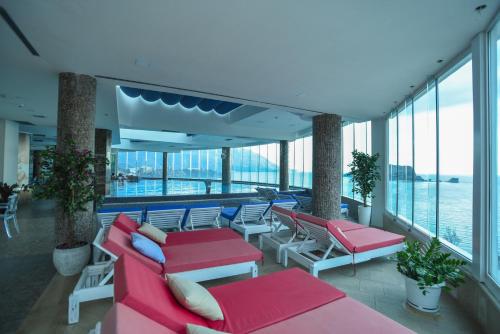 a balcony with red and white furniture and the water at Luxury Apartments Tre Canne Can in Budva