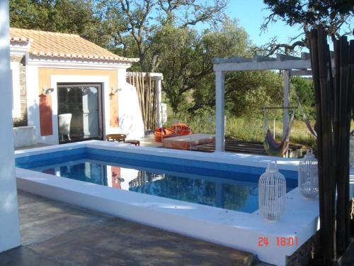 a swimming pool in a backyard with a house at Monte dos Binos in Porto Covo