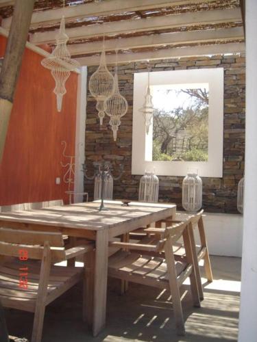 a wooden table with chairs and chandeliers in a room at Monte dos Binos in Porto Covo