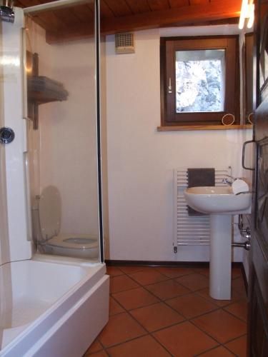 a bathroom with a toilet and a sink and a tub at Le Rocher in Châtillon