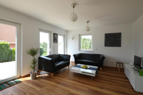 a living room with two black leather chairs and a table at Ferienhaus Caputh in Caputh
