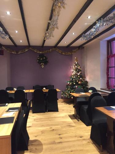 a christmas tree in a room with tables and chairs at The Falcon Inn Retreat in Aberdare