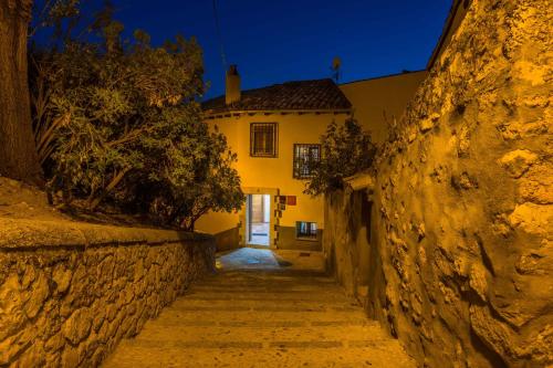 un callejón que conduce a una casa por la noche en Apartamentos San Martin en Cuenca