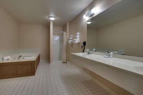 a bathroom with two sinks and a tub and a shower at Heritage Grand Inn in Canton