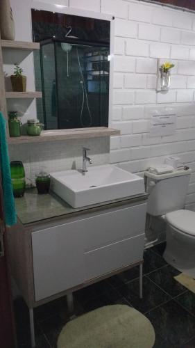 a bathroom with a sink and a toilet at Casa Mágica in Praia do Rosa