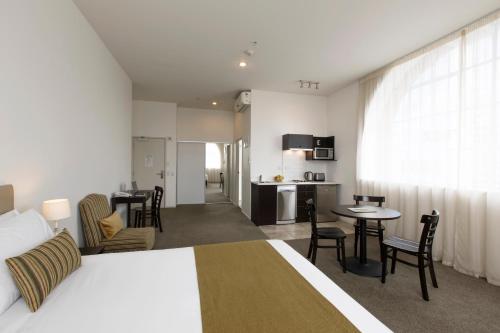 a hotel room with a bed and a kitchen at Quest on London in Hamilton
