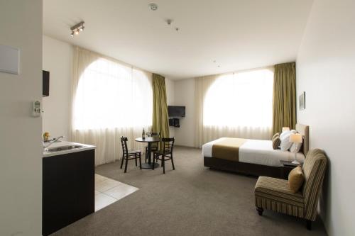 um quarto de hotel com uma cama e uma mesa em Quest Hamilton Serviced Apartments em Hamilton