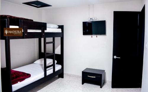 Cette chambre comprend 2 lits superposés et une porte. dans l'établissement Hotel Madeira, à Manizales
