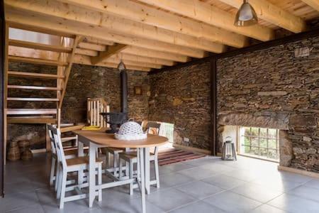 a dining room with a table and a brick wall at Casa de ferias em Caminha - Minho - in Caminha