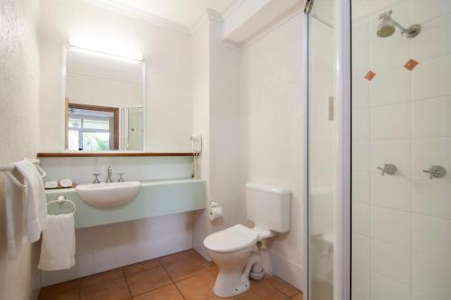 a bathroom with a toilet and a sink and a shower at Port Douglas Retreat in Port Douglas