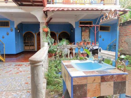a blue house with a sink in a yard at Hostal Siero in Moyogalpa