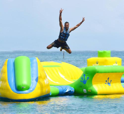 a man jumping off a water slide in the ocean at Shangri-La Yanuca Island, Fiji in Voua